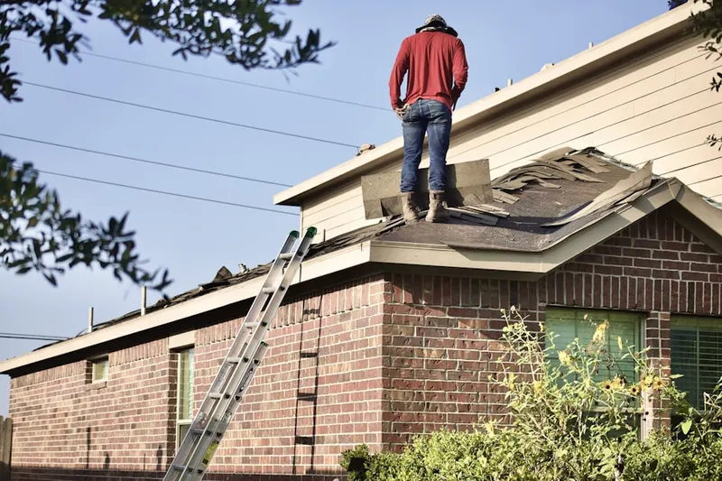 Professional roofer working on a residential roof in Carroll Corners